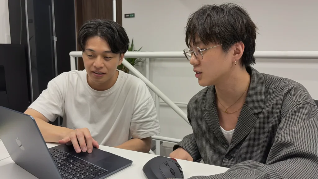 パソコンを囲んで打ち合わせをするメンバー